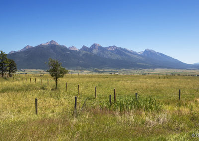 Distant mountains rise above summer fields