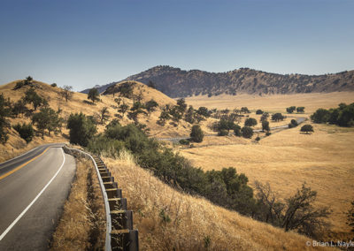 Country road winds into golden valley