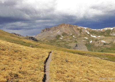 Golden pastures and stormy mountain peaks